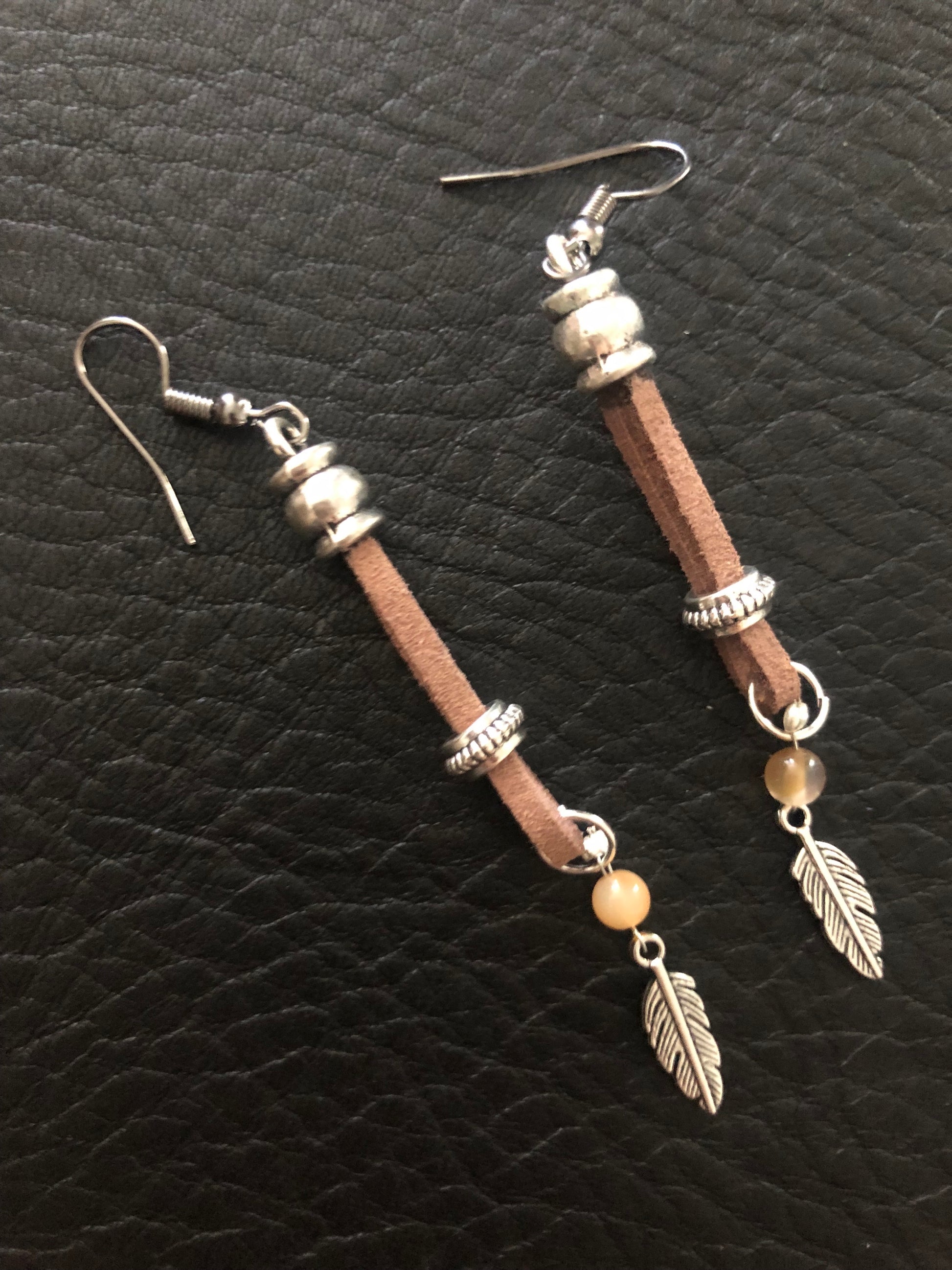 Paire de boucles d'oreilles: cuir beige perle tibétaine Cornaline: - sur le plan psychique: apaise, absorbe les énergies négatives, apporte l'optimisme, donne confiance - sur le plan physique: renforce le système immunitaire, équilibre la sexualité, renforce les ligaments et les os. Plume Longueur 8 cm environ Acier inoxydable.